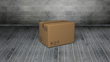 Animation-of-cardboard-box-falling-on-grey-wooden-floor-with-grey-bricks-in-background