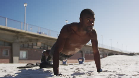Fokussierter-Afroamerikanischer-Mann,-Der-Liegestütze-Macht-Und-Draußen-Am-Strand-Trainiert