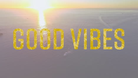 Animation-of-the-words-good-vibes-written-in-yellow-letters-with-sun-setting-over-tranquil-sea