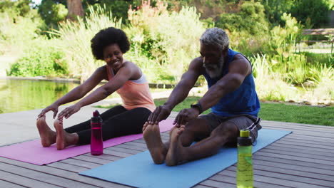 Afroamerikanisches-älteres-Paar,-Das-Im-Freien-Trainiert-Und-Sich-Im-Sonnigen-Garten-Dehnt