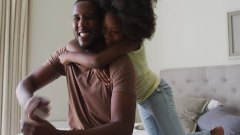 Hija-Afroamericana-Saltando-Sobre-Su-Padre-Y-Abrazándolo
