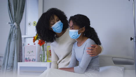 Afroamerikanische-Mutter-Mit-Gesichtsmaske-Nimmt-Und-Tröstet-Ihre-Tochter-Im-Krankenhaus
