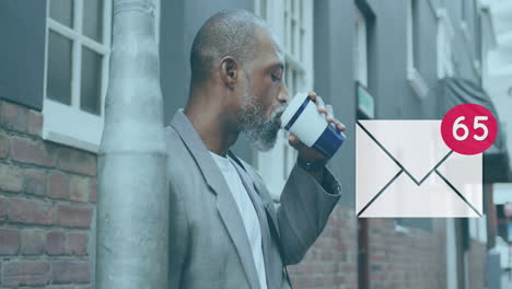 Message-icon-with-increasing-numbers-against-african-american-senior-man-drinking-coffee
