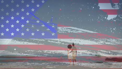 American-flag-with-glitch-effect-against-rear-view-of-couple-walking-on-the-beach