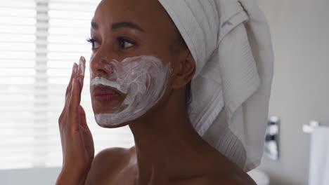 Nahaufnahme-Einer-Afroamerikanischen-Frau,-Die-Im-Badezimmer-Eine-Gesichtsmaske-Anwendet