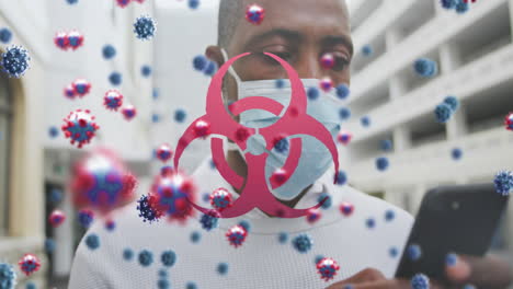 Animation-of-covid-19-cells-and-biohazard-symbol-over-man-in-face-mask-using-smartphone