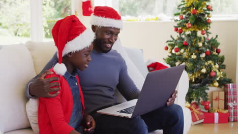 African-american-father-and-son-having-a-videocall-on-laptop