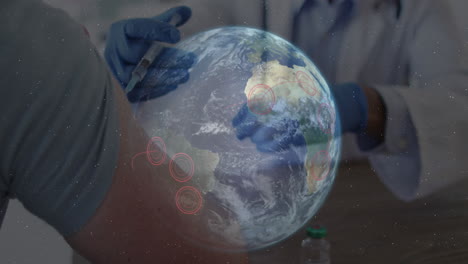 Animation-Eines-Globus-Mit-Roten-Standortpunkten-über-Einem-Mann,-Der-Eine-Impfung-Erhält
