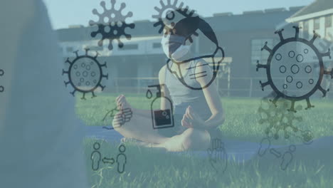 Multiple-covid-19-concept-icons-floating-against-boy-wearing-practicing-yoga-in-the-garden-at-school