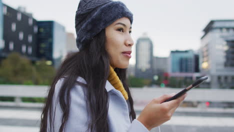 Asian-woman-walking-and-talking-on-smartphone