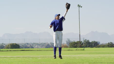 Jugadora-De-Béisbol-Caucásica,-Jardinera-Saltando-Y-Atrapando-Pelota-En-El-Campo-De-Béisbol