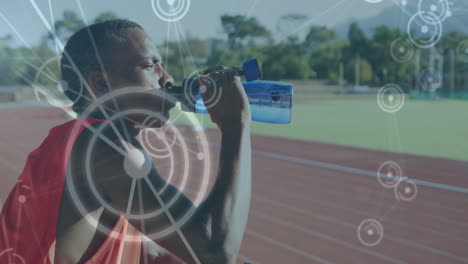 Animation-of-network-of-connections-over-male-athlete-with-drinking-water-on-running-track