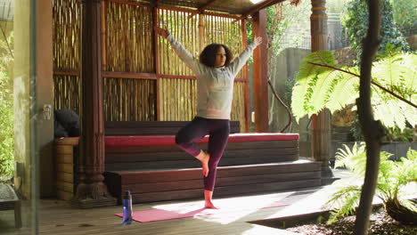 African-american-woman-practicing-yoga-and-meditating-at-vacation-home