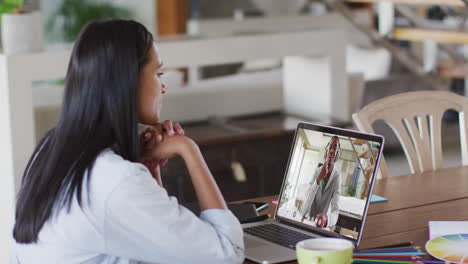 African-american-female-teacher-having-video-call-with-male-college-student-on-laptop-at-home