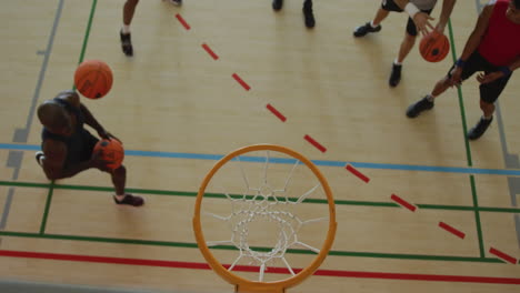 Overhead-view-of-african-american-male-basketball-player-scoring-goal-against-diverse-players