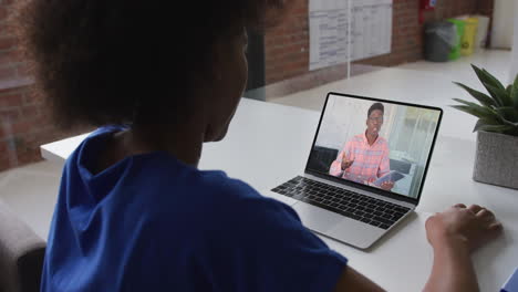 Mujer-Afroamericana-Hablando-Por-Videollamada-Con-Un-Colega-Masculino-En-Una-Computadora-Portátil-En-La-Oficina