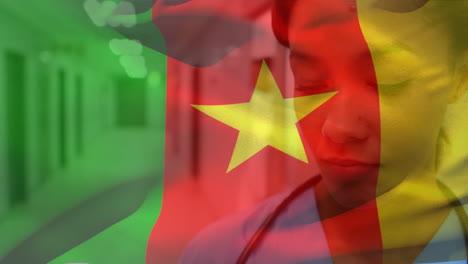 Digitale-Komposition-Einer-Kamerunischen-Flagge,-Die-über-Einer-Afroamerikanischen-Gesundheitshelferin-Im-Krankenhaus-Weht