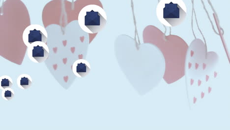 Multiple-message-icons-floating-over-hanging-heart-shape-decorations-against-white-background