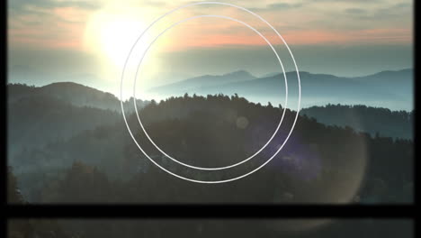 Animation-of-circular-scope-and-slipping-frame-over-idyllic-misty-mountain-landscape-at-sunset