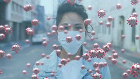 Animation-of-covid-19-virus-cells-over-woman-wearing-face-mask