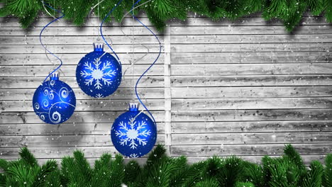 Animation-of-christmas-baubbles-over-wooden-background
