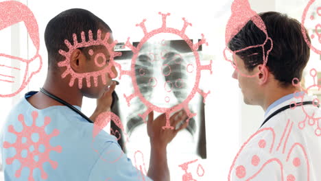 Animation-of-virus-icons-over-smiling-diverse-male-doctors-inspecting-xray