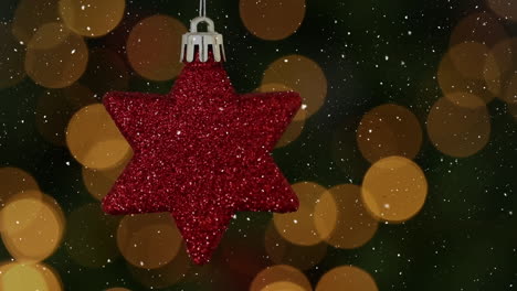 Animation-of-snow-falling-over-red-star-christmas-bauble-decoration