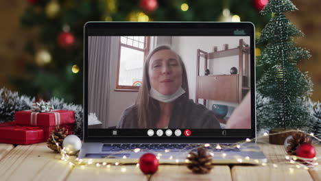 Caucasian-senior-women-in-face-mask-on-video-call,-with-christmas-tree