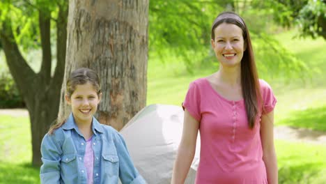 Happy-family-on-a-camping-trip-with-mother-and-daughter-smiling-at-camera