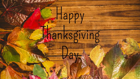 Animation-of-happy-thanksgiving-day-text-over-autumn-leaves-and-wooden-surface