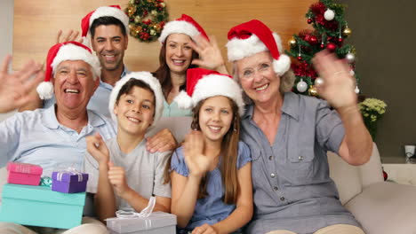 Glückliche-Großfamilie-Winkt-Zur-Weihnachtszeit-In-Die-Kamera
