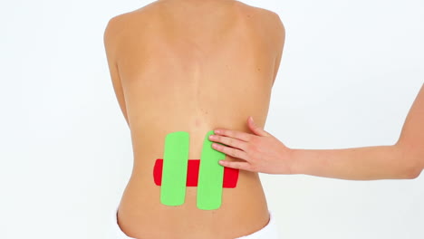Woman-having-red-and-green-kinesio-tape-applied-to-back