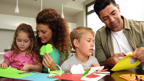 Glückliche-Eltern-Und-Kinder,-Die-Am-Küchentisch-Kunsthandwerk-Machen