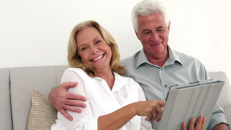 Glückliches-Paar-Im-Ruhestand,-Das-Sein-Tablet-Auf-Der-Couch-Benutzt