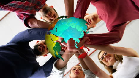 Animation-of-globe-over-work-colleagues-stacking-hands-in-background