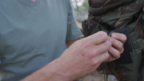 Hands-of-caucasian-male-survivalist-untying-paracord-at-camp-in-wilderness