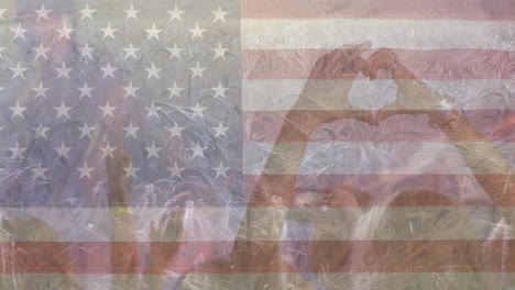 Animation-of-american-flag-with-wheat-field-and-hands-making-heart