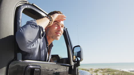 Happy-caucasian-man-in-car-admiring-the-view-on-sunny-day-at-the-beach