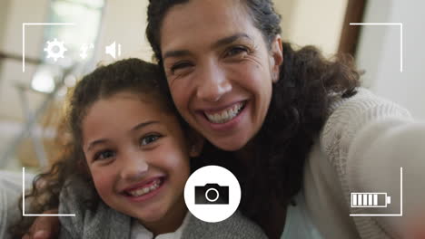 Animation-of-frame-over-happy-biracial-mother-with-daughter-taking-selfie