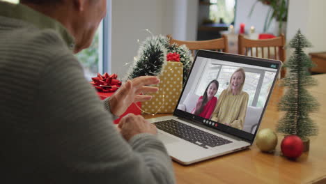 Happy-caucasian-senior-man-on-video-call-on-laptop-with-daughter-and-granddaughter-at-christmas