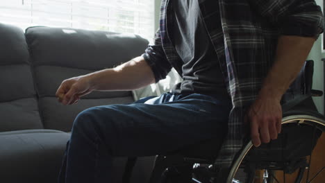 Kaukasischer-Behinderter-Mann-Im-Rollstuhl,-Der-Auf-Dem-Sofa-Im-Wohnzimmer-Sitzt