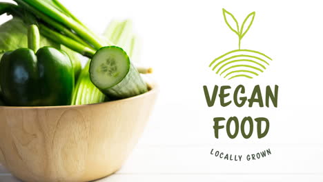 Animation-of-vegan-food-locally-grown-text-in-green,-over-fresh-green-vegetables-in-wooden-bowl