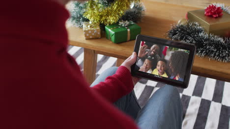 Kaukasischer-Mann-Winkt-Und-Benutzt-Tablet-Für-Weihnachtsvideoanruf-Mit-Lächelnder-Familie-Auf-Dem-Bildschirm