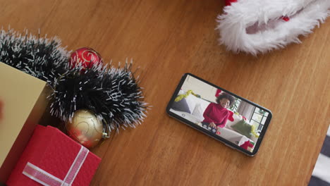 Lächelnde-Afroamerikanische-Frau-Mit-Weihnachtsmütze-Bei-Weihnachtsvideoanruf-Auf-Dem-Smartphone