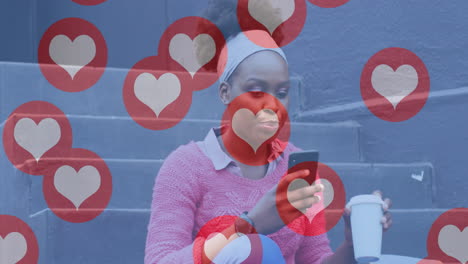 Animation-Von-Social-Media-Herzsymbolen-über-Einer-Glücklichen-Afroamerikanischen-Frau-Auf-Der-Straße-Mit-Smartphone