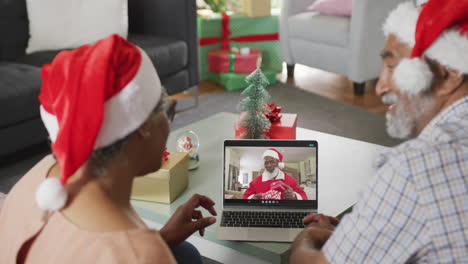 Happy-african-american-senior-couple-on-video-call-with-santa-claus-at-christmas