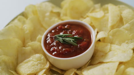 Video-of-crisps-and-salsa-dip-on-a-grey-surface