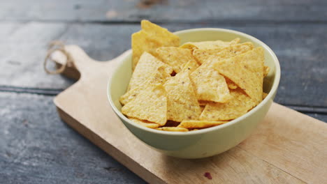Close-up-view-of-bowl-of-nachos-on-wooden-tray-with-copy-space-on-wooden-surface