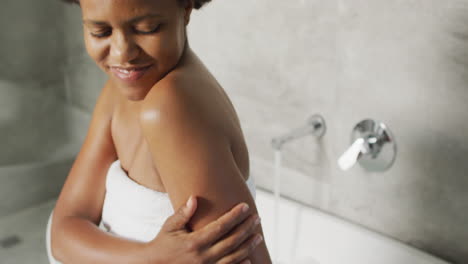 Glückliche-Afroamerikanische-Frau,-Die-Im-Badezimmer-Ein-Bad-Vorbereitet