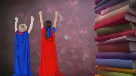 Animation-of-letters-moving-over-boy-and-girl-in-superhero-capes-and-stack-of-books